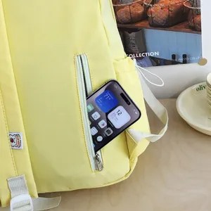 Primo piano dettagliato dello zaino giallo con comoda tasca anteriore con zip e cinghie eleganti.