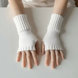 Primer plano de guantes de punto blanco sin dedos usados en las manos con textura.