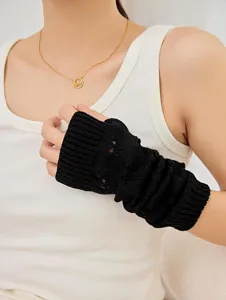 Close-up detail of black knitted arm warmer sleeve, showcasing soft texture and cozy wear.