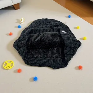 Vista dettagliata della cuffia in maglia a trecce nera con fodera peluche inverno.