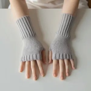 Vista detallada de guantes de punto grises sin dedos, mostrando el diseño de canalé.