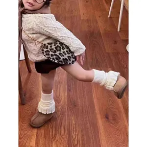 Detailed view of children knitted leg warmers, trendy warm winter slouch socks for girls.