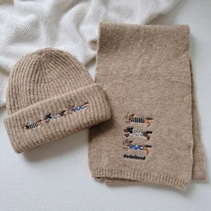 Detail shot of the cute dachshund embroidered knit scarf and beanie set in beige wool blend.