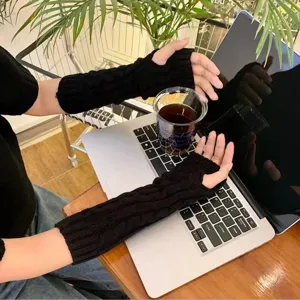 Black knitted arm warmers fingerless gloves cozy winter thermal sleeve detail view.