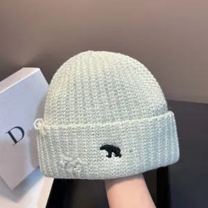Detailopname van de gebreide muts met schattige ijsbeer borduursel en coole beschadigde details.