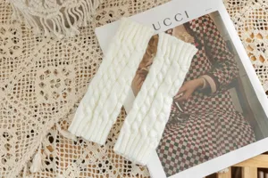 Cable knit fingerless gloves detail shot, cozy autumn winter arm warmers in white.