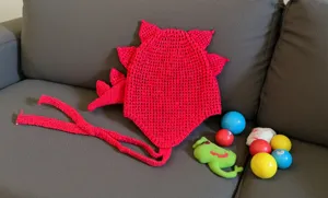 Accesorio de invierno de dinosaurio tejido en rojo vista detallada con púas únicas.