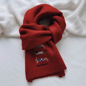 Detailed view of the red knitted wool blend scarf featuring cute dachshund embroidery.