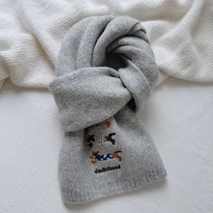 Close-up view of the grey knit scarf featuring cute dachshund embroidery and cozy texture.