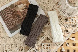 Knit fingerless gloves featuring classic cable design, warm wool material in black, brown, and white.