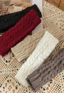 Close-up of cable knit fingerless gloves, winter warm arm warmers in assorted cozy colors.