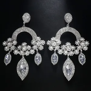 Gros plan détaillé de boucles d'oreilles chandelier en strass scintillants et cristaux.