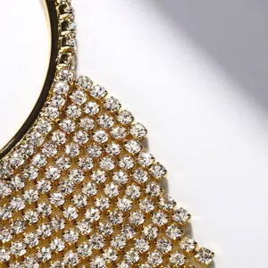 Nahaufnahme des goldenen Strass Fransen Ohrrings im Detail mit funkelnden Kristallen.