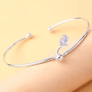 Detailaufnahme eines silbernen offenen Armreifs mit Tropfen-Zirkonia für den täglichen Look.