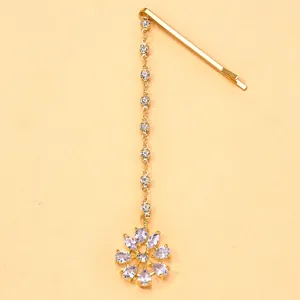 Détail de chaîne de cheveux en strass dorés, accessoire pendentif fleur en cristal.