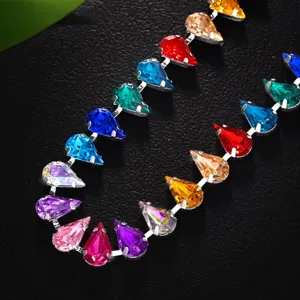 Primo piano della catena corpo in strass colorati a goccia, gioiello da festival vivace.