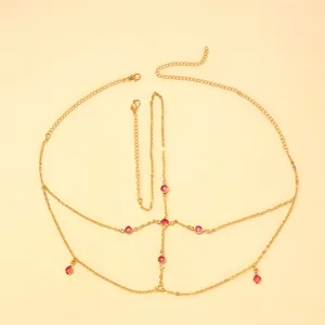 Détail délicat de chaîne de front dorée multicouche avec pendentifs rouges pour le décor de fête.