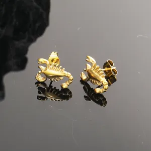 Detalle de cerca de pendientes de tachuela de escorpion de acero titanio para hombres.