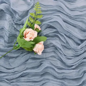 Vista dettagliata del runner da tavola in mussola boho con delicate decorazioni di rose.