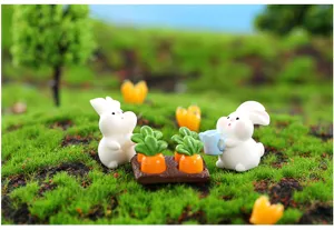 Primer plano detallado de bonitas miniaturas de conejitos de resina con zanahorias.