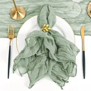 Sage green gauze napkin detail with gold leaf napkin ring for boho wedding table decor.