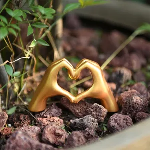 Detailed view of Nordic luxury gold hand heart gesture statue ornament desktop decor