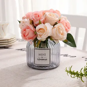 Artificial rose bouquet detail, pink and white flowers in a glass vase, elegant table decor.