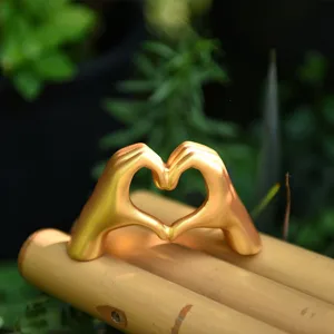 Nordic minimalist golden heart hand gesture sculpture, stylish desktop decor for gift.