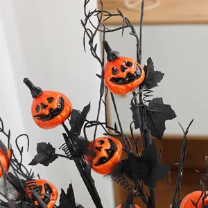 Detalle de decoración rama calabaza Halloween, ramita negra espeluznante con calabaza fiesta.