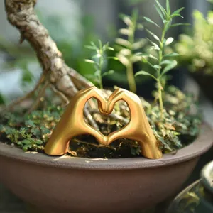 Gold heart gesture sculpture detail showing minimalist Nordic decor for home table.