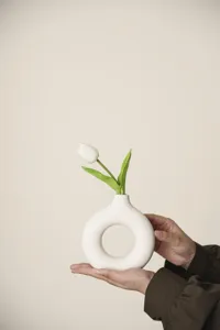 Minimalist Nordic ceramic donut vase with white tulip for modern home decor detail view.