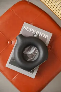 Nordic minimalist black ceramic donut vase, modern artistic ring-shaped home decor tabletop.