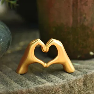Golden heart hand gesture sculpture ornament, minimalist Nordic decor for home table or romantic gift.