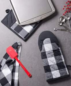 Black and white buffalo plaid oven mitts and pot holders kitchen baking set with red spatula.