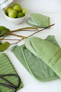 Détail de gants de cuisine et maniques verts, ensemble de tapis de cuisson résistants à la chaleur.
