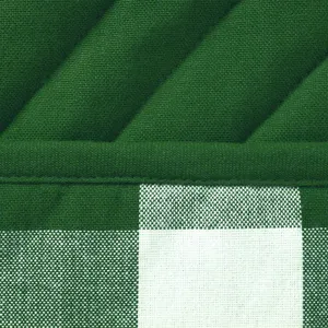 Detailed shot of green quilted and checkered kitchen oven mitt and heat pad fabric.