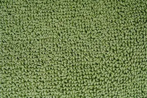 Detail de texture de tissu bouclete uni vert pour gants et tapis isolants de cuisine maison.