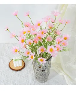 Close-up of pink artificial daisy flower arrangement inside a textured glass vase.