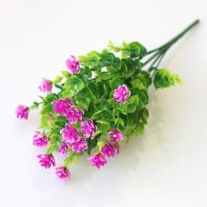 Detailed close-up of artificial purple flowers and green leaves, perfect for decoration.