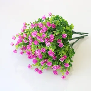 Artificial flower detail shot, pink floral bouquet with green leaves, close-up view.