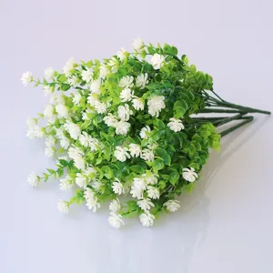 Detailed close-up view of artificial white flowers and green leaves, perfect for wall decor.