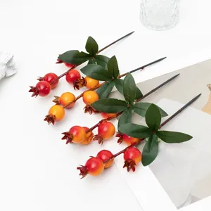 Primo piano di rami di melograno artificiale, bacche rosse realistiche per bellissime decorazioni.