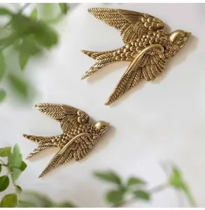 Vintage golden swallow wall hanging detail showing exquisite feather texture and decor.