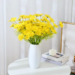 Artificial yellow chamomile flowers in white ceramic vase, elegant home decor and prop.
