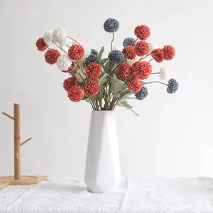 Künstlicher Pompon-Chrysanthemen-Blumenstrauß in weißer geometrischer Vase für Heimdekoration.