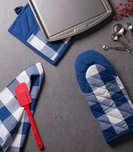 Detailed shot of blue and white buffalo check oven mitt and potholder set on grey surface.