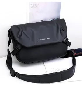 Black oxford cloth messenger bag detail showing flap closure and adjustable shoulder strap.