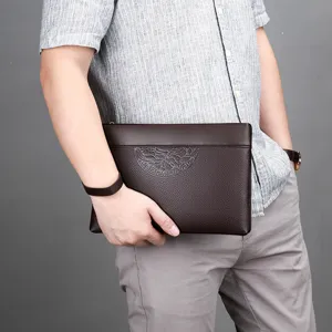 Men's stylish brown leather clutch bag with embossed pattern and convenient wrist strap.