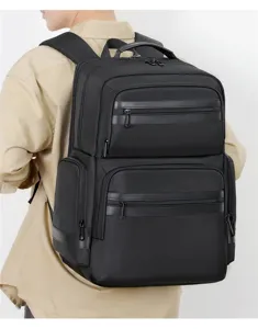 Detail view of black business backpack showing multi-compartment design and zippers.