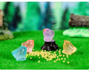Close-up detail shot of colorful resin little bird figurines for micro landscape decor.